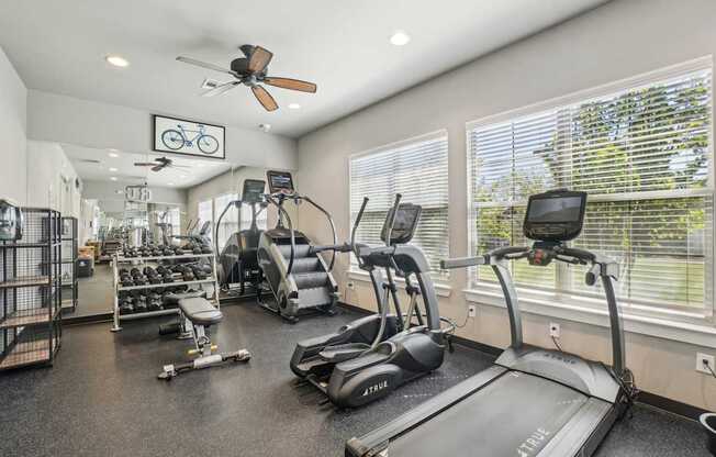 A gym with treadmills, elliptical machines, and other exercise equipment.