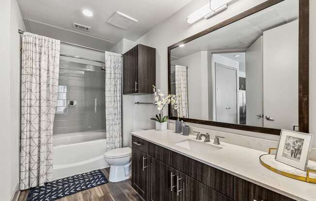 A bathroom with a white toilet, a sink, and a mirror.