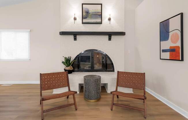 A living room with a fireplace and two chairs.