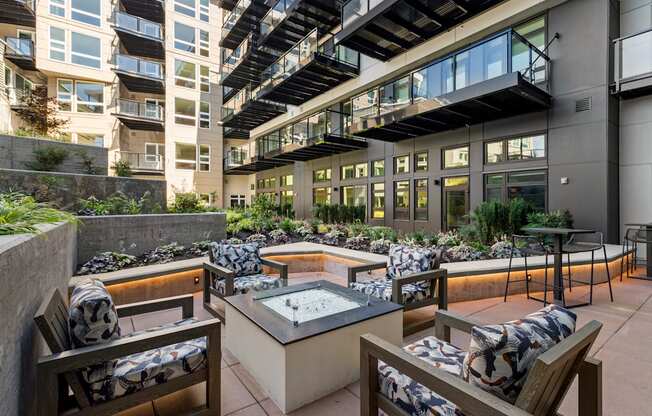 Vela Apartments outdoor patio with a firepit and lounge chairs
