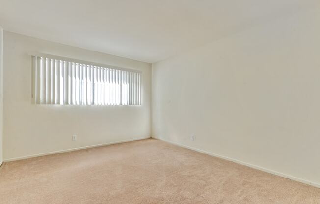 Bedroom with carpeting, vertical blinds on the window