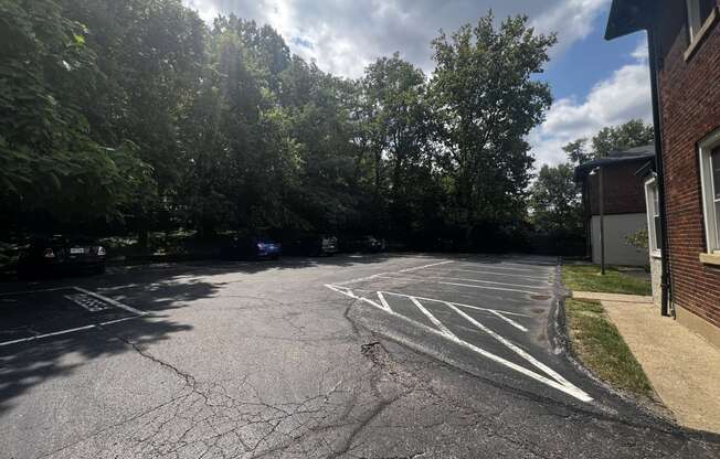 a parking lot with a building and trees at Cincinnati Premier Living*, Cincinnati