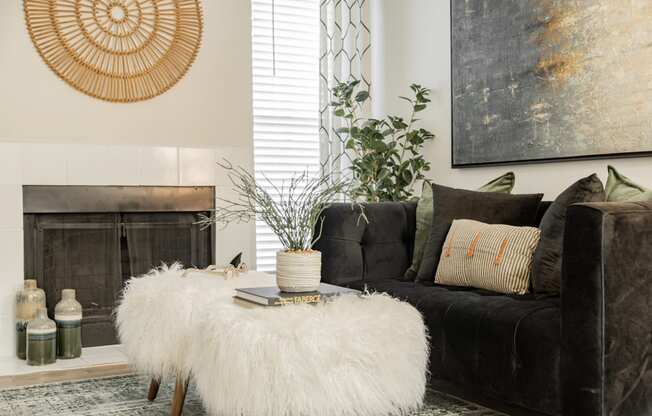 a living room with a couch and a coffee table with a furry stool