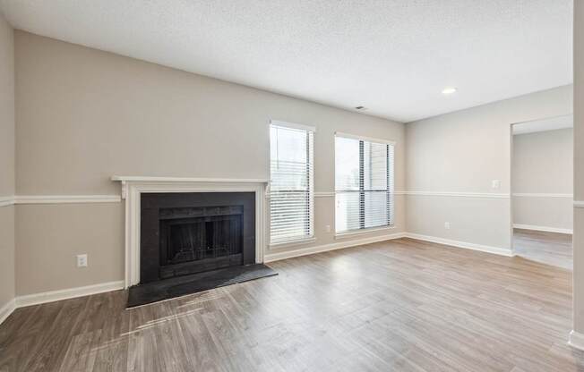 A living room with a fireplace and wood flooring.