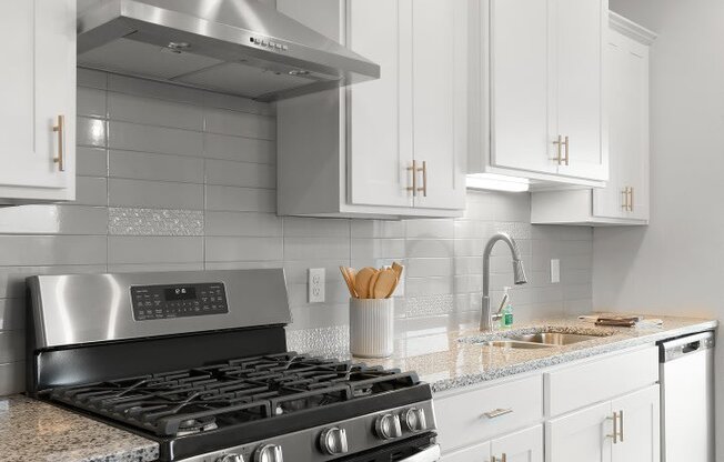 a white kitchen with stainless steel appliances and white cabinets