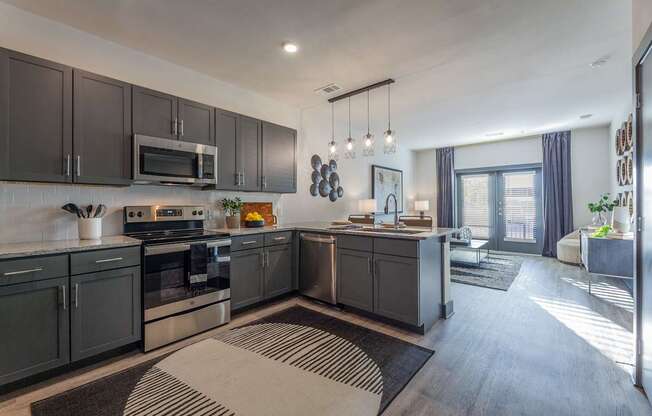 A modern kitchen with dark grey cabinets and a large island.