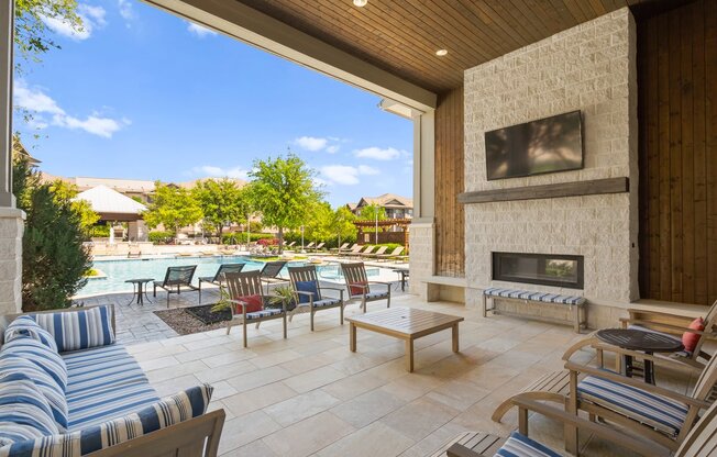 the outdoor living area has a fireplace and a swimming pool