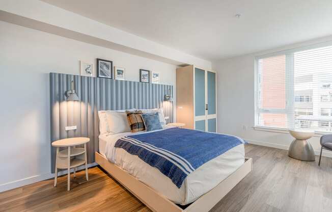 a bedroom with a bed and a chair in front of a window at Marina Square, Washington