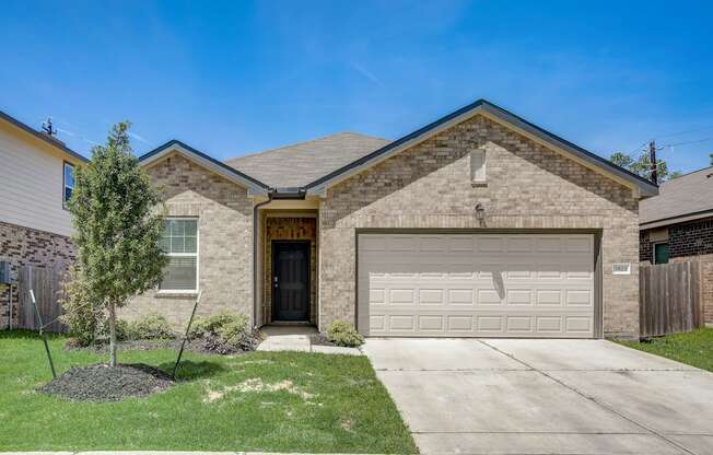 a tan brick house with a white garage door