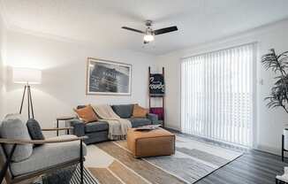 our apartments offer a living room with a couch and a ceiling fan