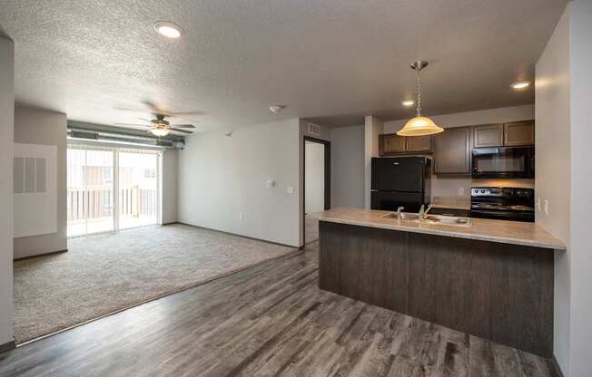 A kitchen with a black fridge and microwave.