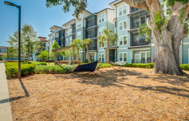 a hammock on the ground in front of an apartment building