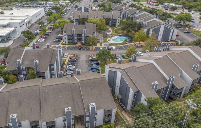 an aerial view of several buildings in a city with a parking lot