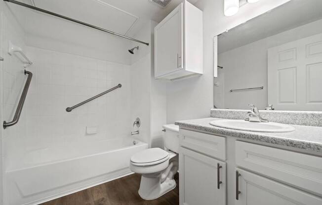 A white bathroom with a toilet, sink, and bathtub.