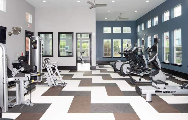 a workout room with treadmills and other exercise equipment
