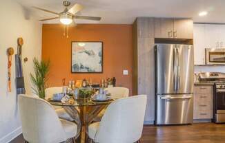 A modern kitchen with a glass dining table and chairs.