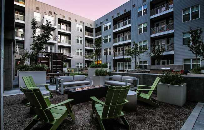A patio with a table and chairs is surrounded by apartment buildings.