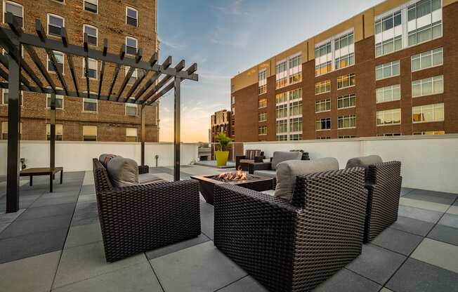 a patio with chairs and a fire pit