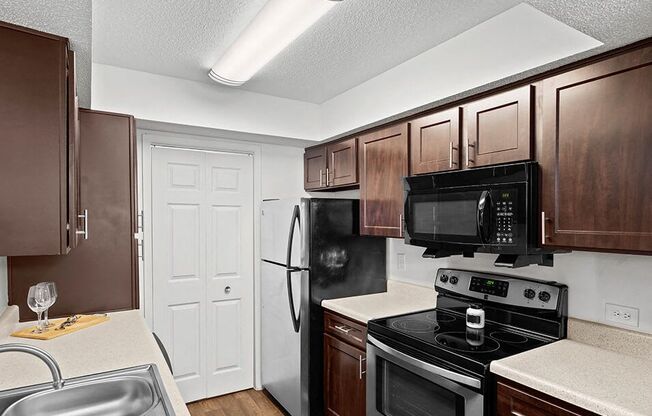 a kitchen with black appliances and wooden cabinets