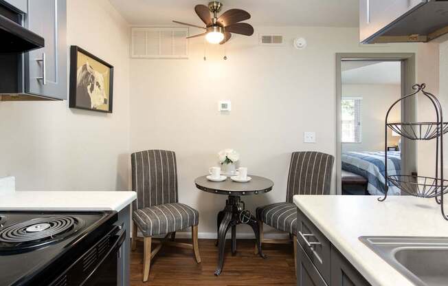 a kitchen with a stove and a table with two chairs