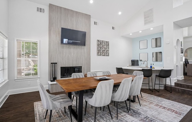 Resident clubhouse with a wooden table and grey chairs.