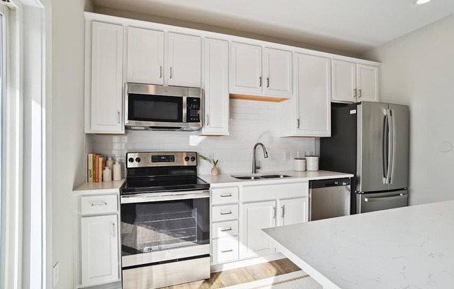 A kitchen with white cabinets and appliances. at Zora University, Charlotte, 28213