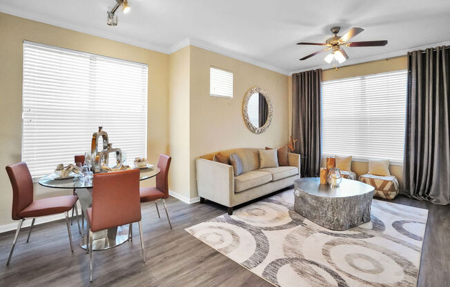 a staged living room with two windows and a ceiling fan