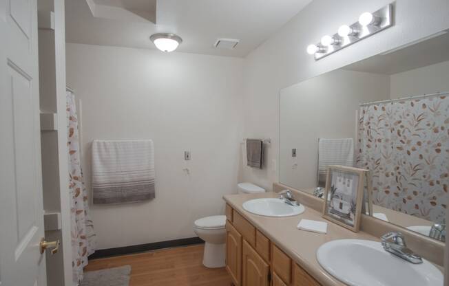 a bathroom with two sinks and a shower and a toilet