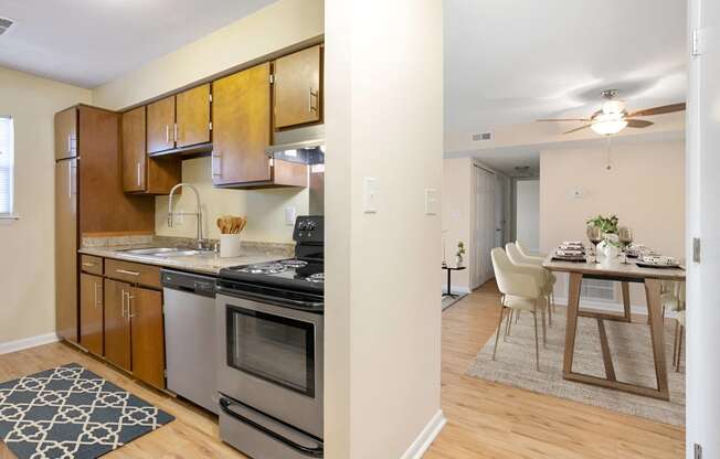 a kitchen with stainless steel appliances and a dining room table at West Pointe Apartments in Burlington, NC