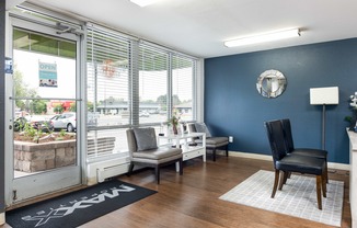 a living room with blue walls and a window with chairs and a table