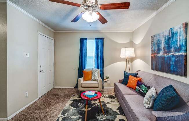 a living room with a ceiling fan and a couch