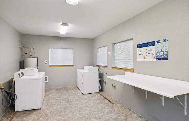 A room with a white wall and a white floor with a white table and a white cabinet.