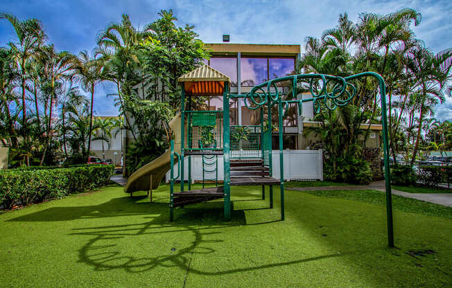 a playground with a slide and a swing at Palms of Kilani Apartments, Hawaii