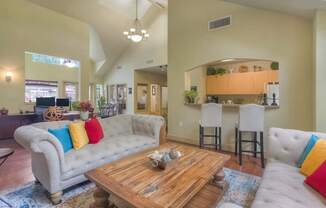 A living room with a white couch and a wooden coffee table.