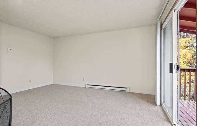 an empty living room with sliding glass doors to a balcony