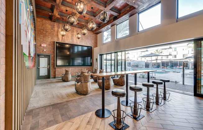 A row of bar stools are arranged in front of a television.