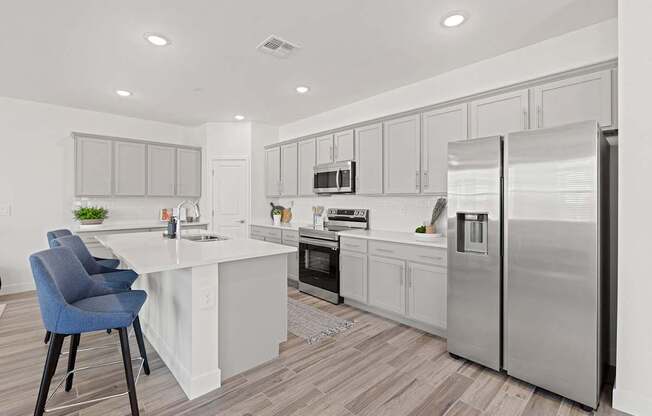 A modern kitchen with a white island and stainless steel appliances.