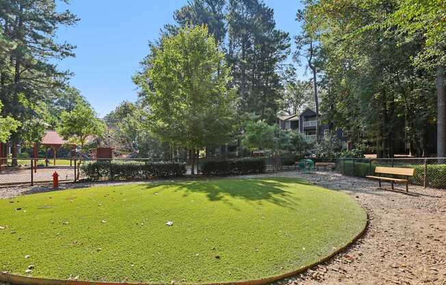 A park with a green lawn and a bench.