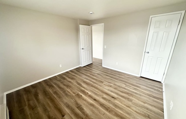 a living room with hard wood flooring and a door