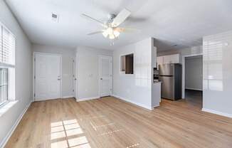 A room with a ceiling fan and wooden flooring.