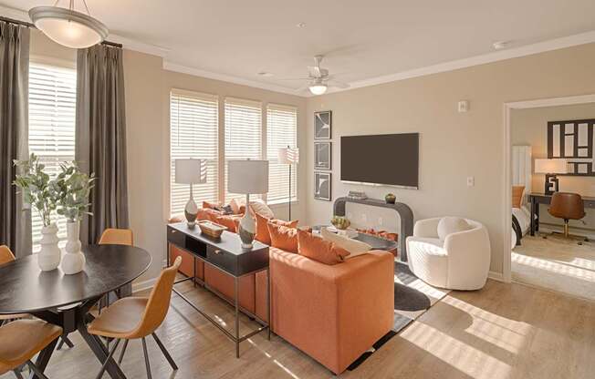A modern living room with a black table and orange sofa.