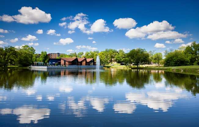 large pond with a water fountain reflecting the blue sky near The Bennington Apartments in Bensenville