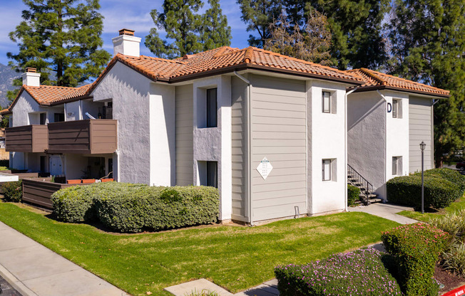 A house with a red tile roof and a grey exterior.