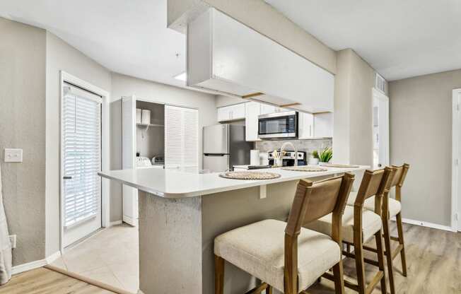 a kitchen with a bar with four chairsat Reserve at Temple Terrace, Florida, 33637