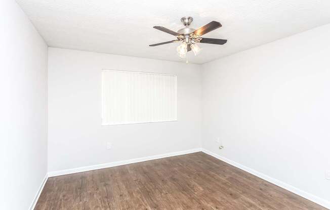 A room with a ceiling fan and a window.