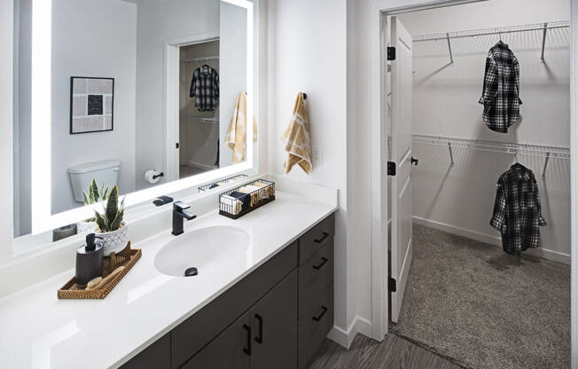 a bathroom with a sink and a mirror and a shower at Aura Vegas Apartments, Las Vegas, NV