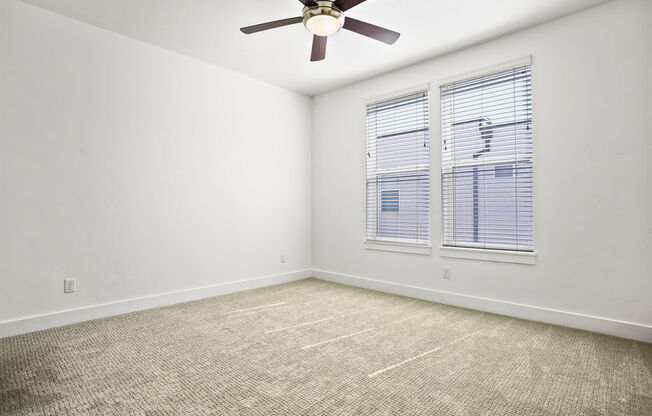 an empty room with a ceiling fan and a window  at Aero Luxury Townhomes in Layton, Utah