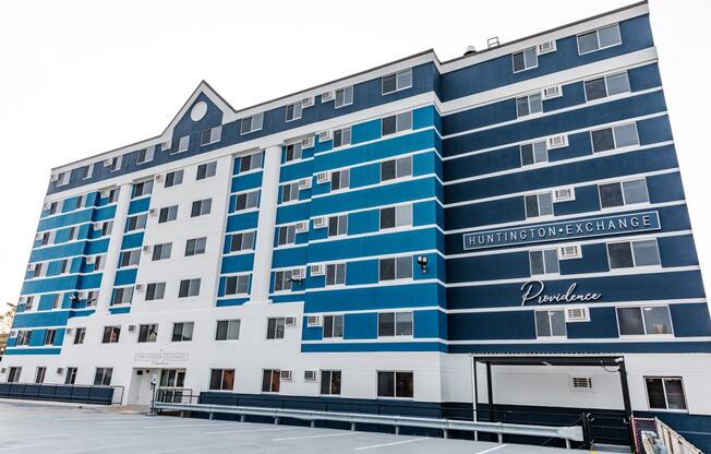 a blue and white building in front of a parking lot