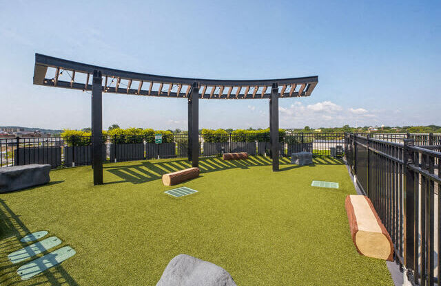 a grassy area with benches and a pergola