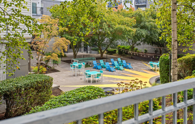 a patio with blue chairs and a fountain in front of a building